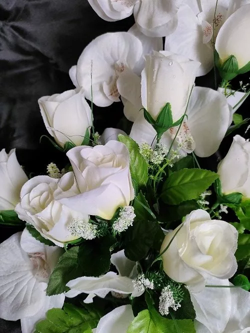 gros plan sur coupe de fleurs artificielles blanches dans pot lesté pour cimetière
