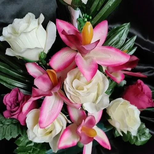 gros plan sur Jardinière de fleurs artificielles rose et blanche dans pot lesté pour cimetière