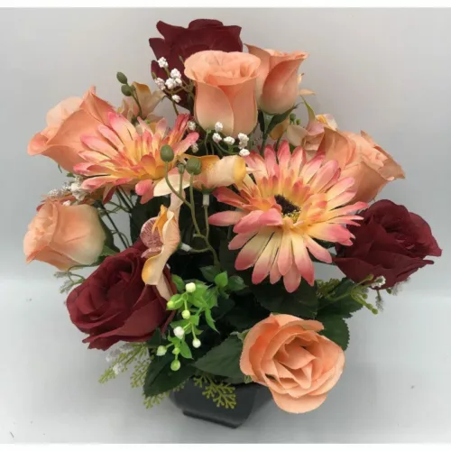 Coupe de fleurs artificielles rouge et saumon dans un pot lestée pour cimetière